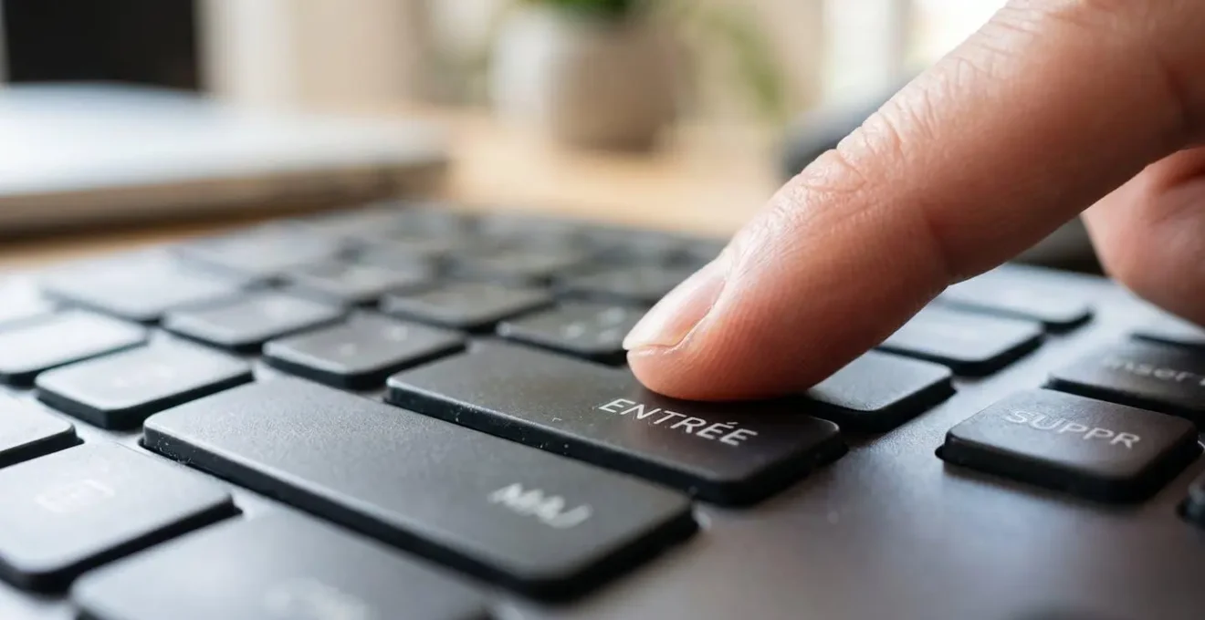 Gros plan d'un doigt sur la touche Entrée d'un clavier moderne avec lumière naturelle latérale et flou artistique en arrière-plan